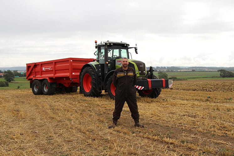 Chris Rodgers standing with Class Axion 810 Tractor
